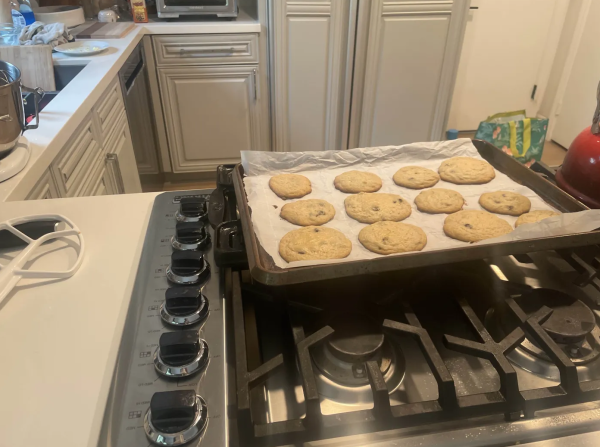 Evan Ravenna '25 pulls freshly made cookies out of the oven to enjoy during the holiday season.